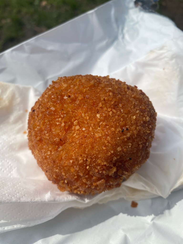 Gluten free arancini ball on a paper bag