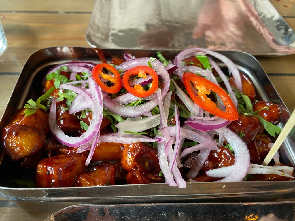 Treacle tamarind fries covered with red onion and chillis