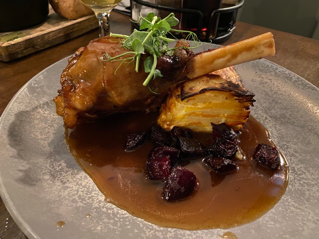 A lamb shank on potatoes and gravy