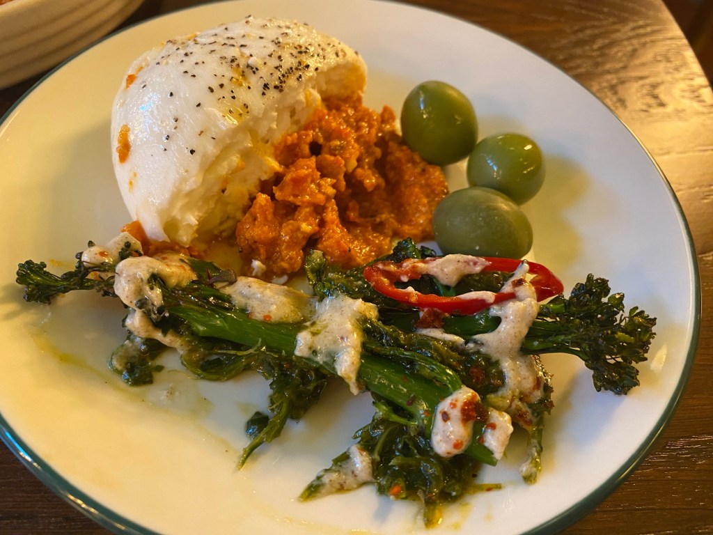 A side plate containing  olives, burrata cheese and tenderstem broccoli