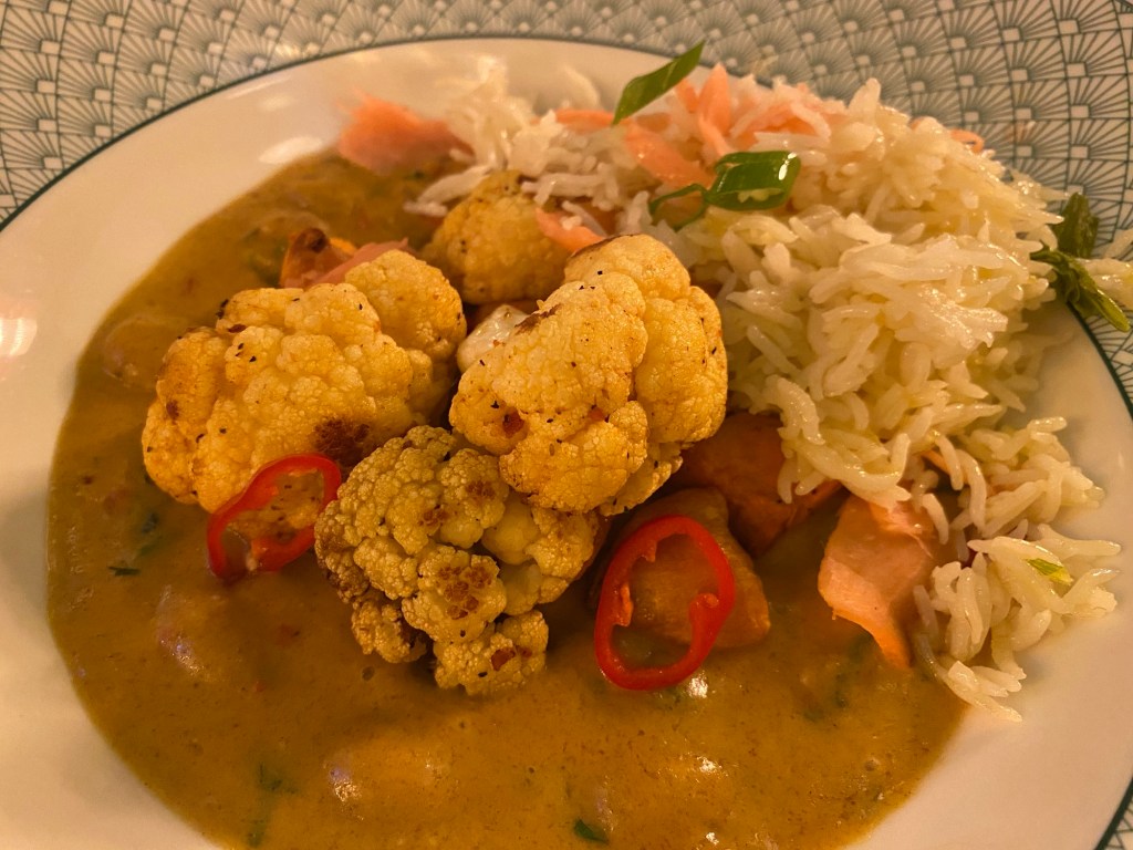 A bowl containing cauliflower Massaman curry and some rice