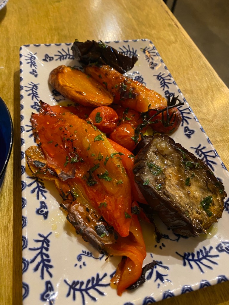 A selection of roasted vegetables (carrot, pepper, aubergine) on a rectangular white platter with a blue pattern