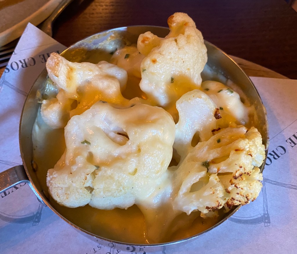 A little metal dish of cauliflower cheese